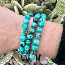 Arizona Chrysocolla beaded bracelets on a wrist with cacti in the background